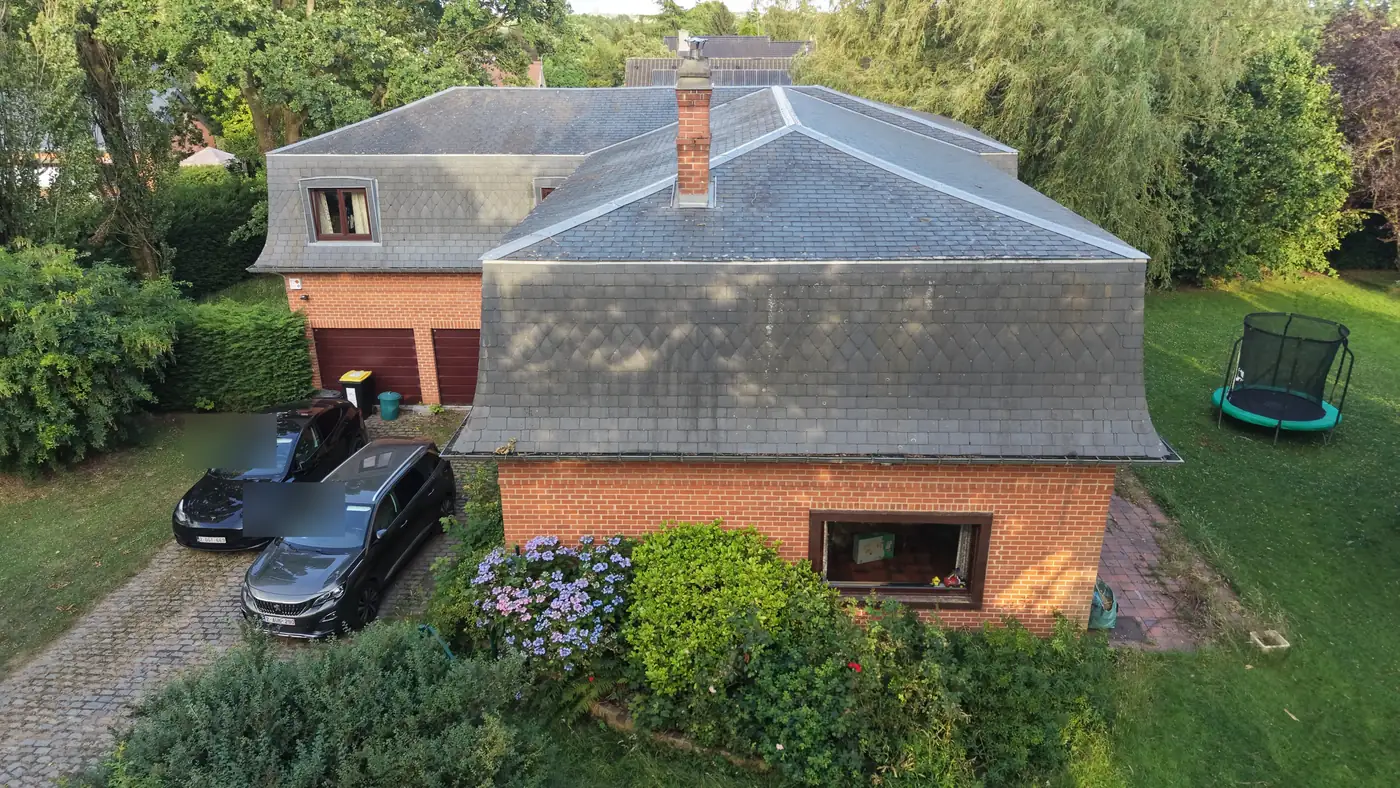 Vue aérienne par drone de la façade arrière d'une villa et de son jardin arboré, Brabant wallon